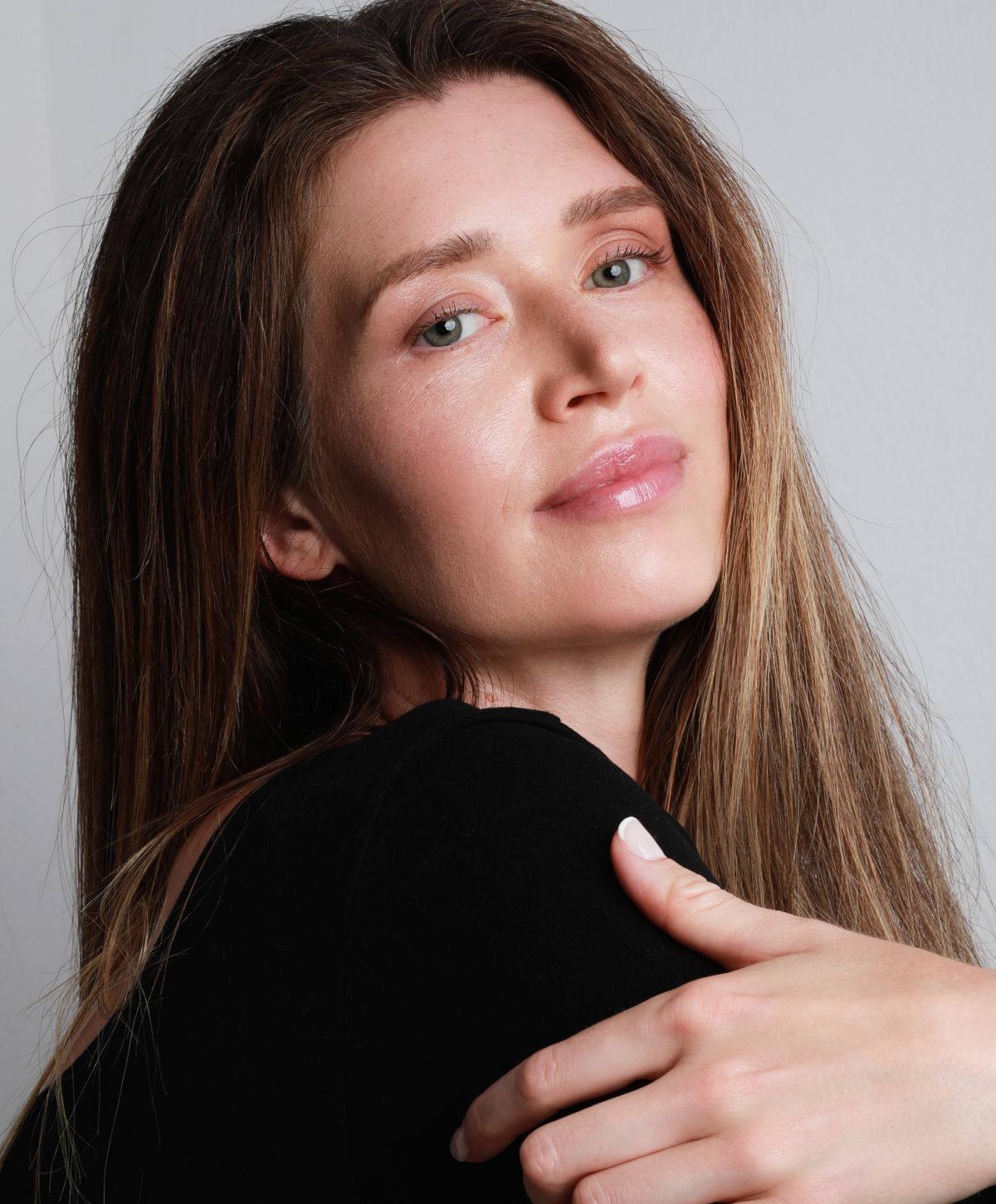 Woman with long hair smiling softly at camera.