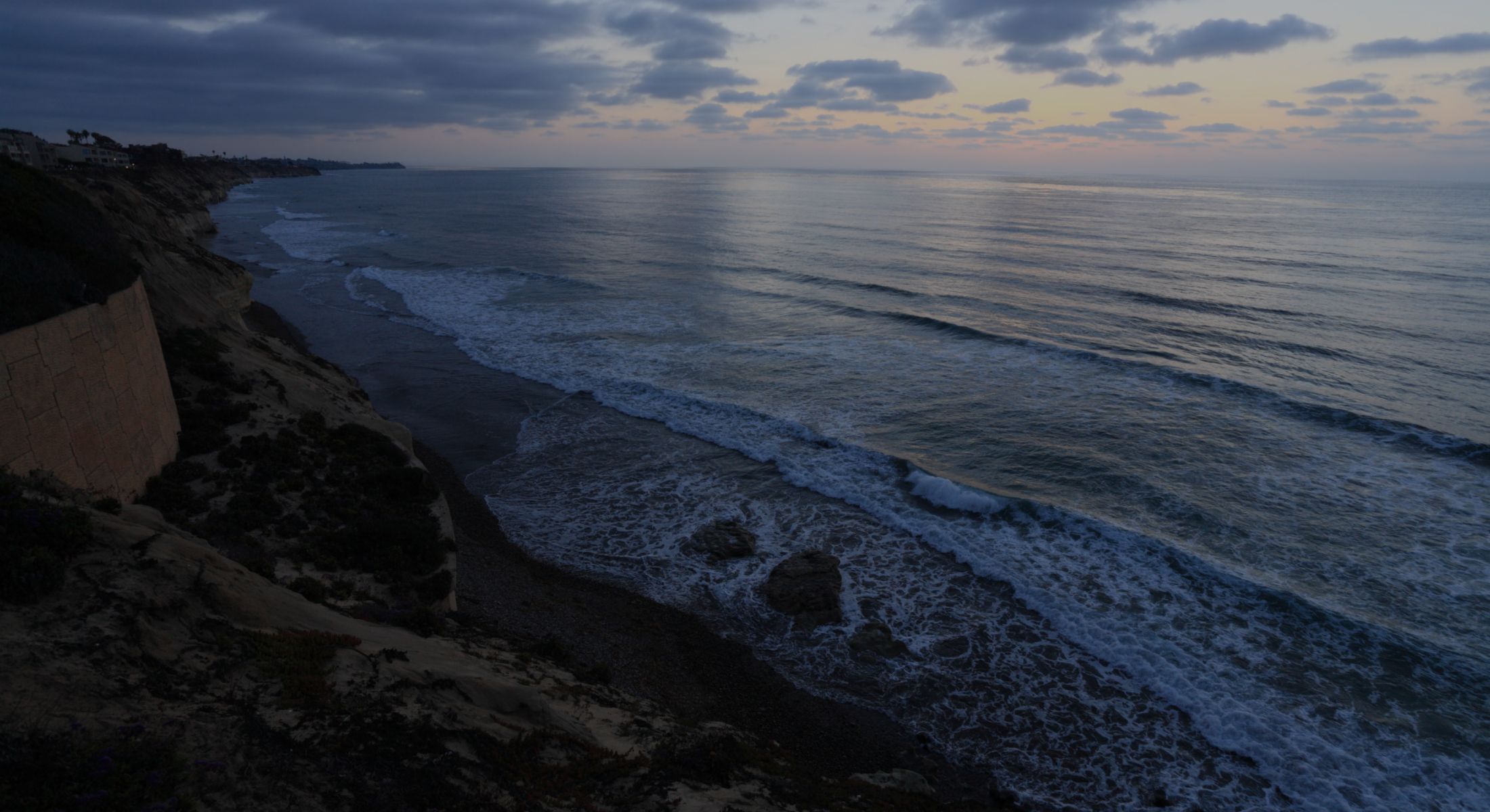 Serene ocean waves at sunset on coastal cliffs.