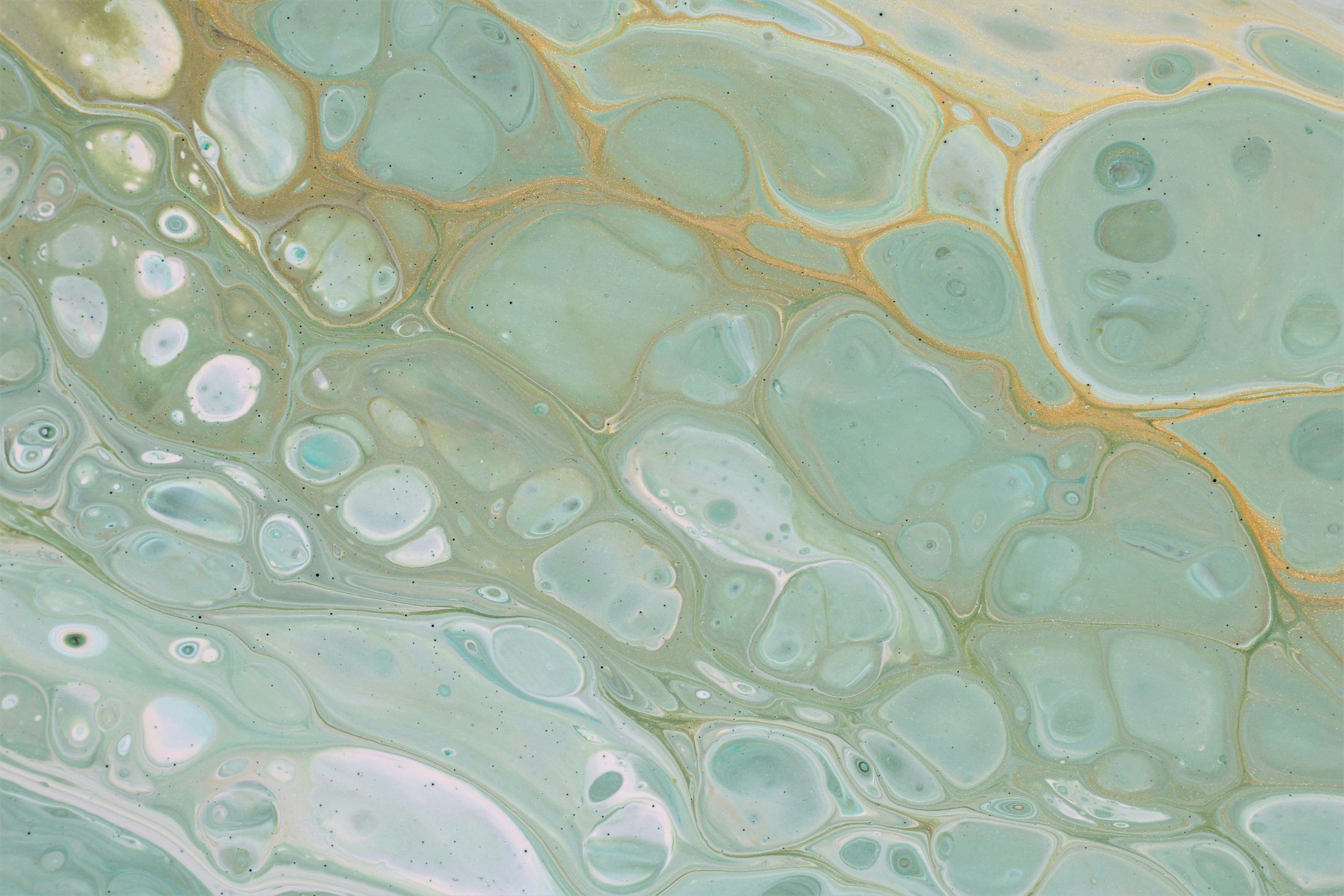 Abstract teal and gold marbled pattern background.